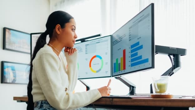 Woman analyzing reports on a desktop computer