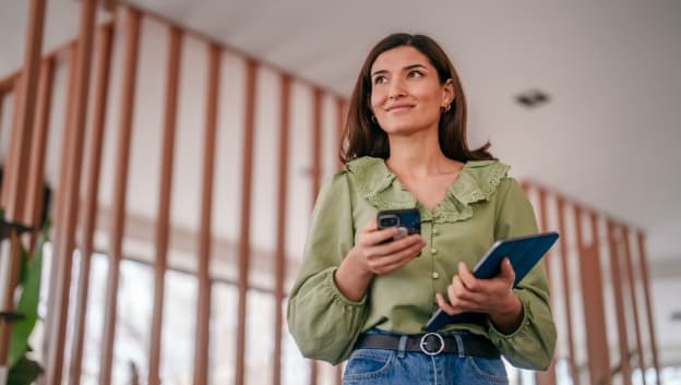 Content woman holding a mobile phone and laptop
